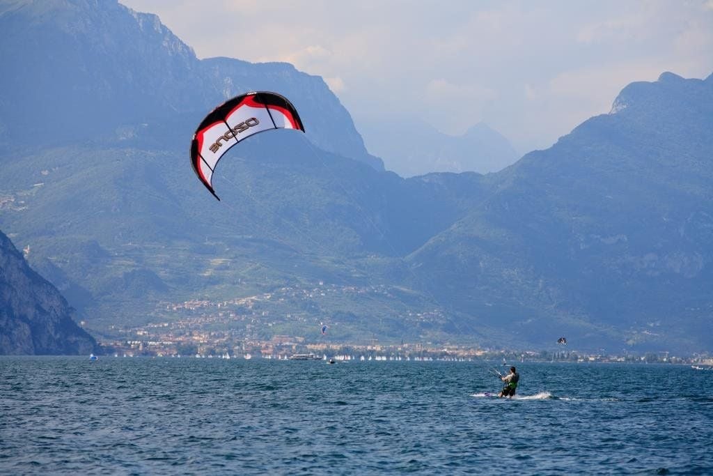 Ein Kitesurfer düst über den Gardasee.