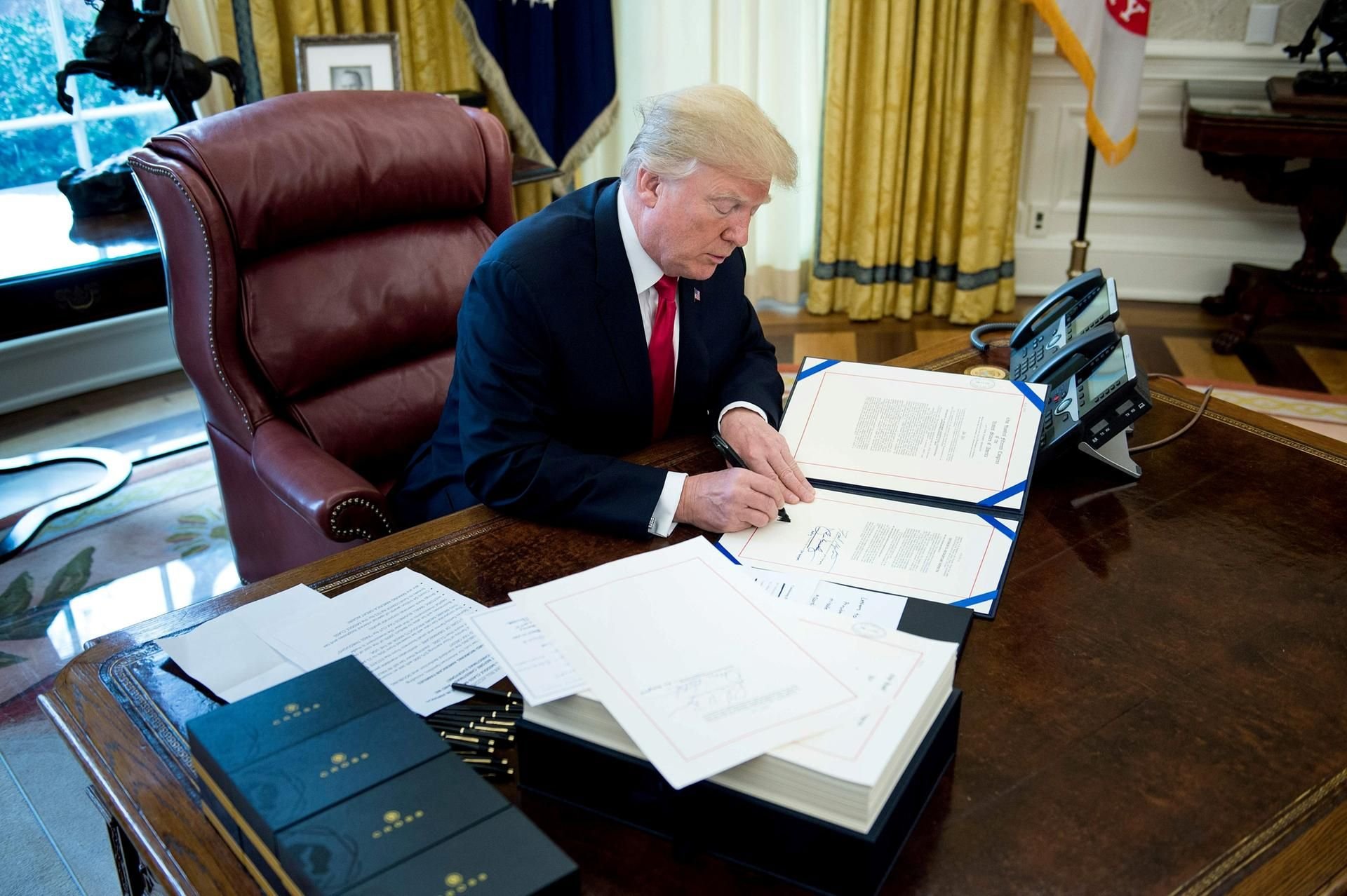 US-Präsident Trump bei der Unterschrift im Oval Office.