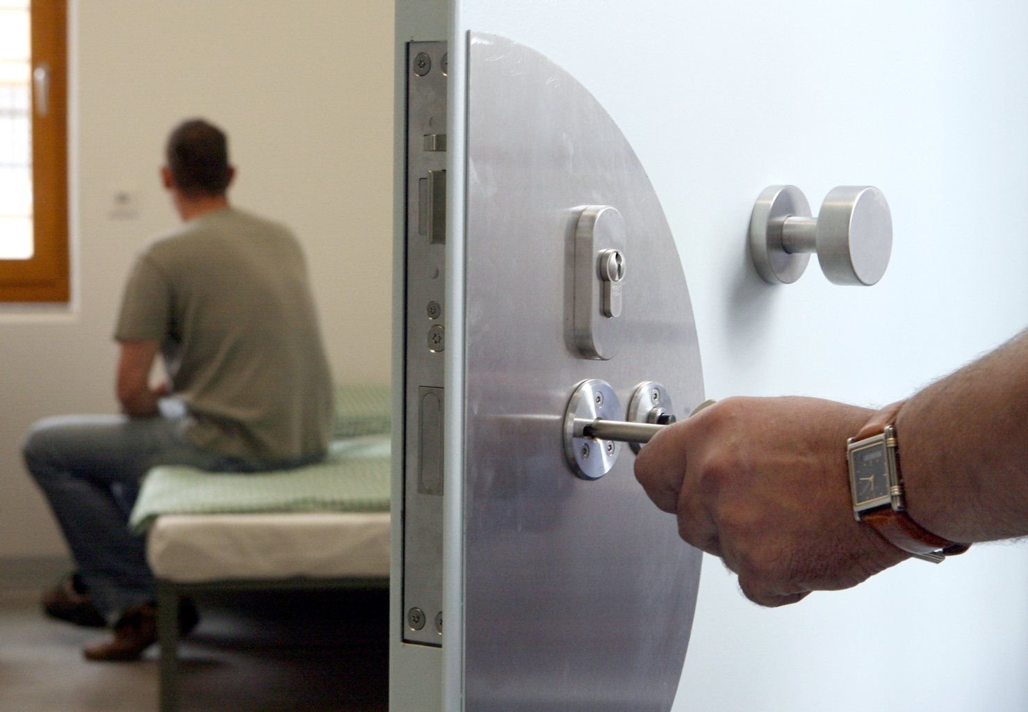 Ein Justizbeamter schließt einen Häftling in seinen Haftraum in einer Jugendhaftanstalt ein.