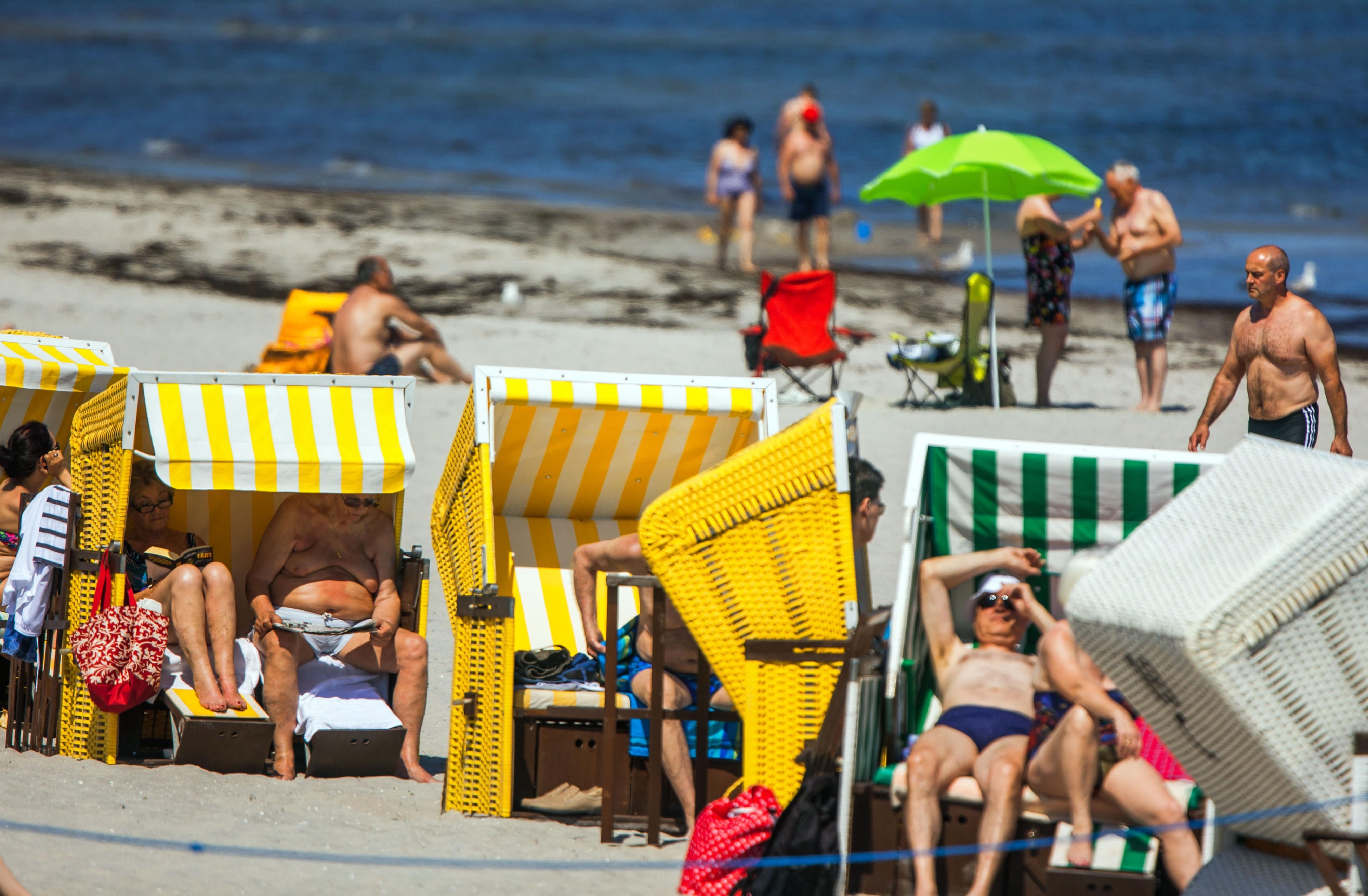 Tagesgäste und Urlauber nutzen am Strand von Boltenhagen (Mecklenburg-Vorpommern) das warme Sommerwetter zu einem Sonnenbad.