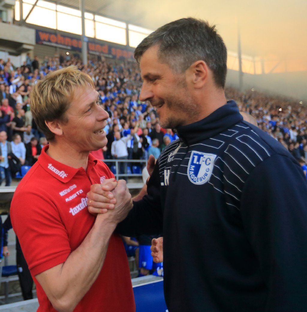 HFC-Trainer Sven Köhler (l) und Magdeburgs Trainer Jens Härtel begrüßen sich vor dem Anpfiff der Partie.