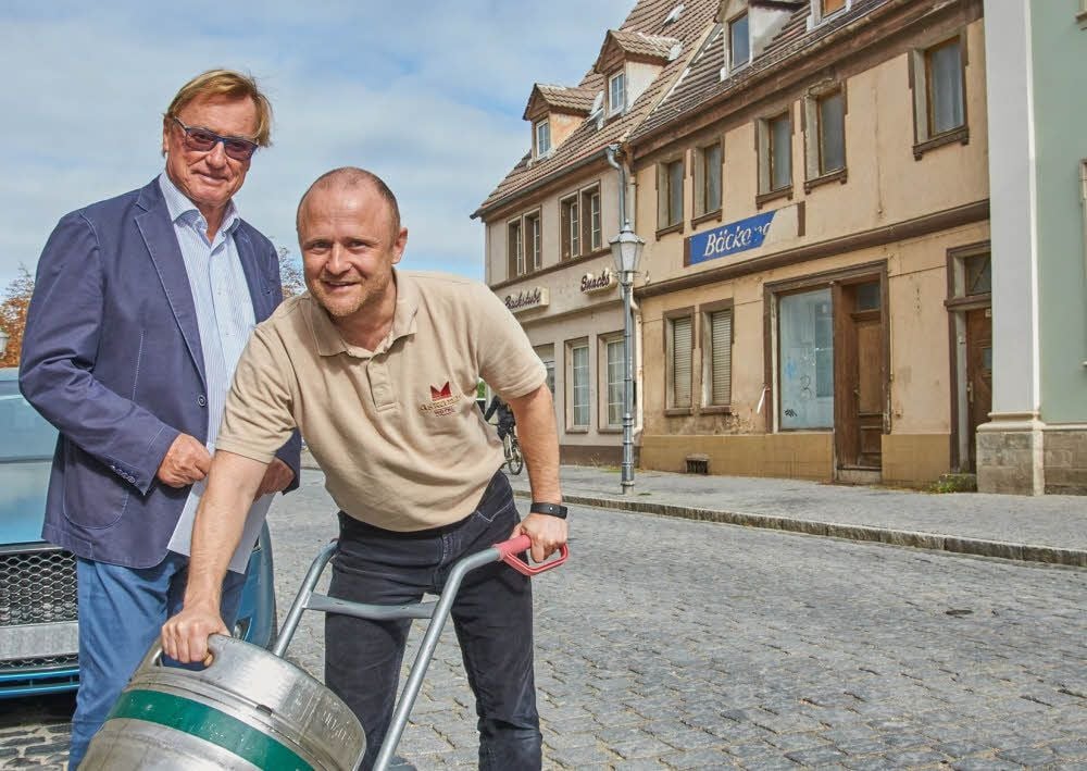 Ein Blick in die Zukunft: Falko Rauch (rechts) bringt selbst gebrautes Bier aus der ehemaligen Bäckerei Kuhlmann über die Breite Straße ins Restaurant „Amadeus“ des Askania-Hotels. Peter Grassmann hat ihm das mehr als zehn Jahre lang leerstehende Gebäude am Donnerstag verkauft.