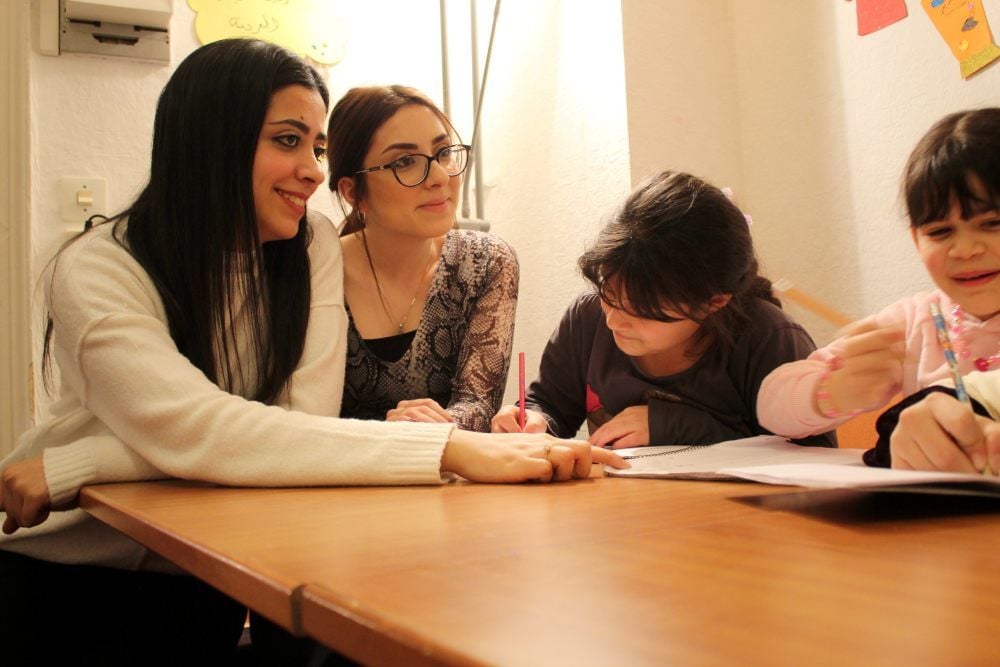 Nada und Shahed Hajjar (M.) unterrichten Kinder im „Coffee to Stay“ in arabischer Schrift.