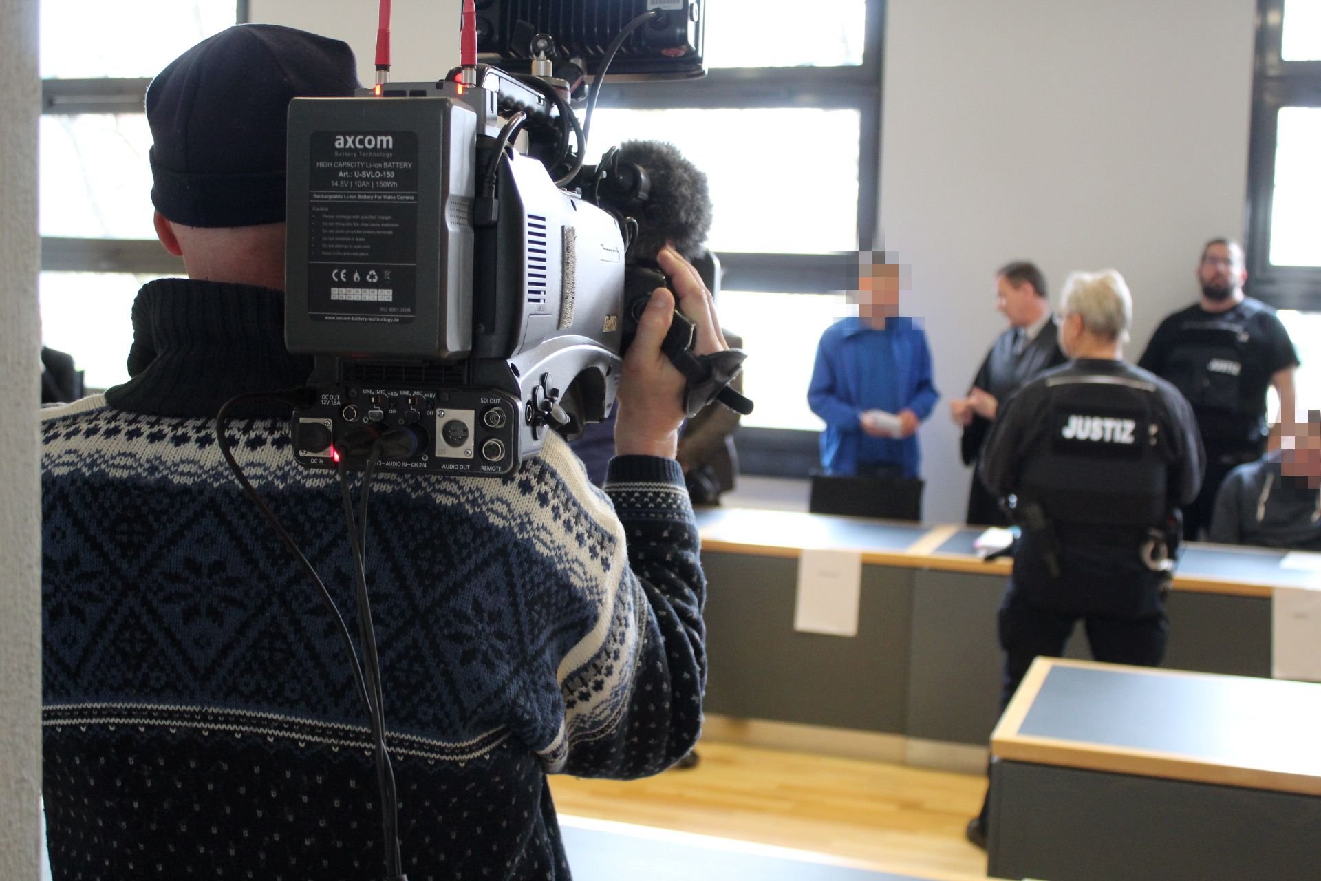 Begleitet von Kameras und Journalisten, nehmen die Angeklagten Platz im Verhandlungssaal des Landgerichtes Magdeburg.
