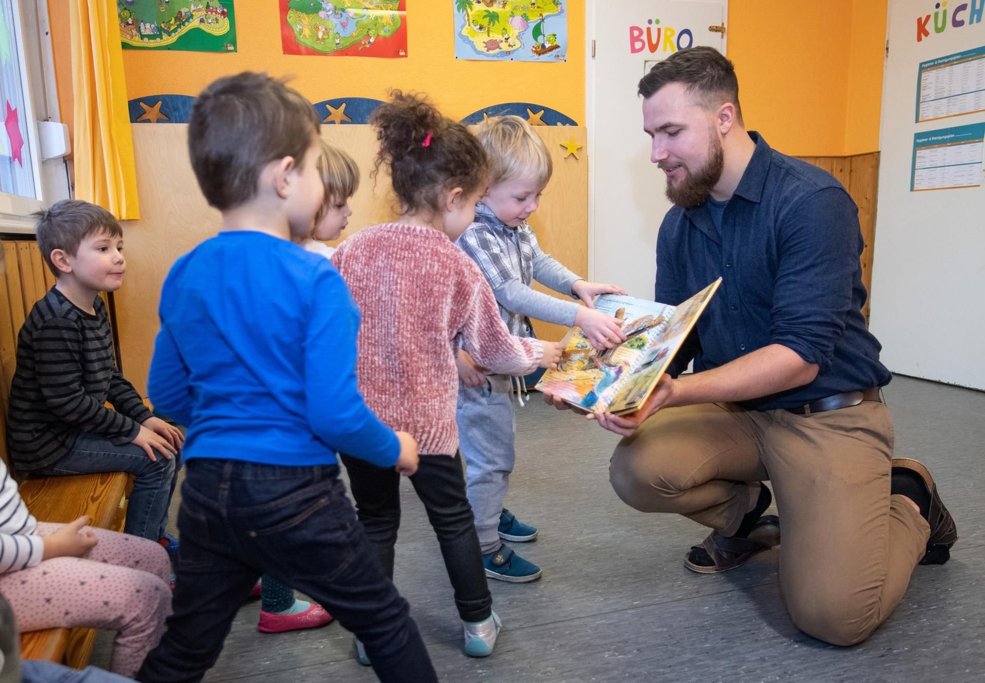 Fabian Salin, Erzieher im Kindergarten Rumpelwichte, bespricht mit Kindern zur musikalischen Früherziehung ein Buch über Zootiere.
