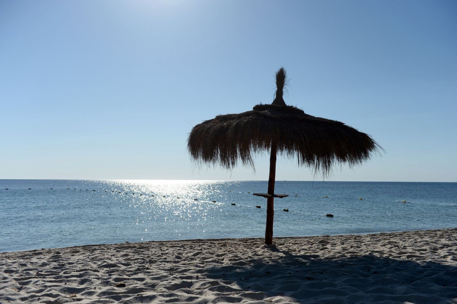 Ein Sonnenschirm steht ungenutzt am Strand vor dem Hotel Imperial Marhaba in Sousse (Tunesien).