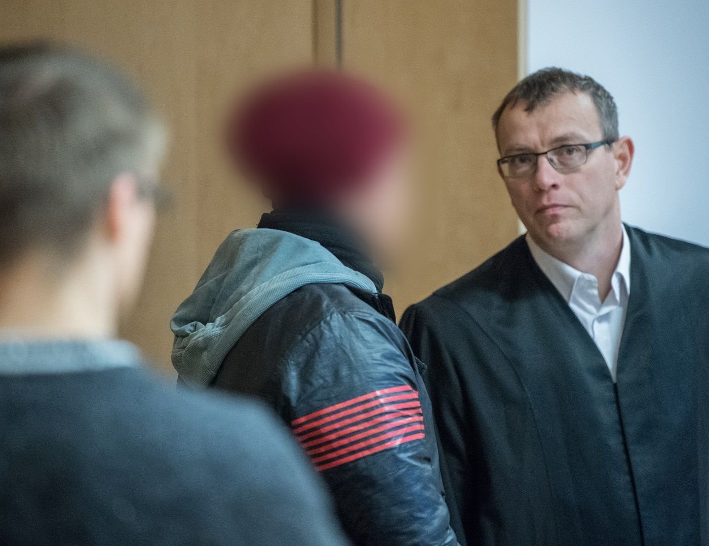 Vor Prozessbeginn unterhält sich der Angeklagte (m.) mit seinem Anwalt Stefan Böhme (r.) auf den Beginn des 13. Verhandlungstages. Auf der Flucht vor der Polizei soll der 25-Jährige in Ostbrandenburg zwei Beamte totgefahren haben, nachdem er zuvor seine Großmutter in ihrem Wohnhaus in Müllrose erstochen haben soll.