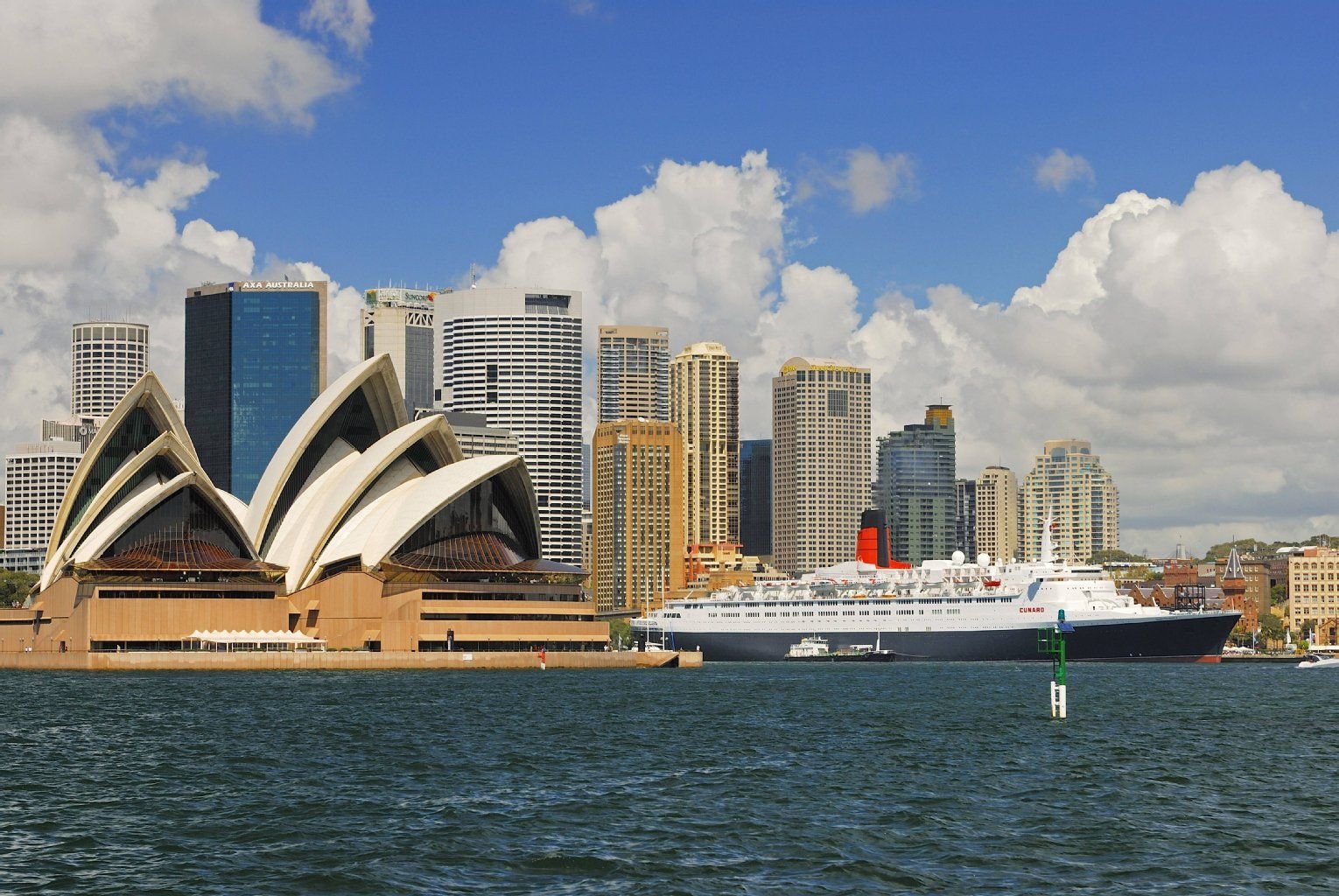 Der Luxusliner Queen Elizabeth 2 fährt durch den Hafen von Sydney. Links das Opernhaus.