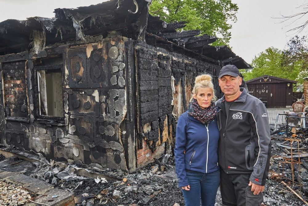 Marco und Susanne Seitschek vor den Trümmern ihres ausgebrannten Hauses.