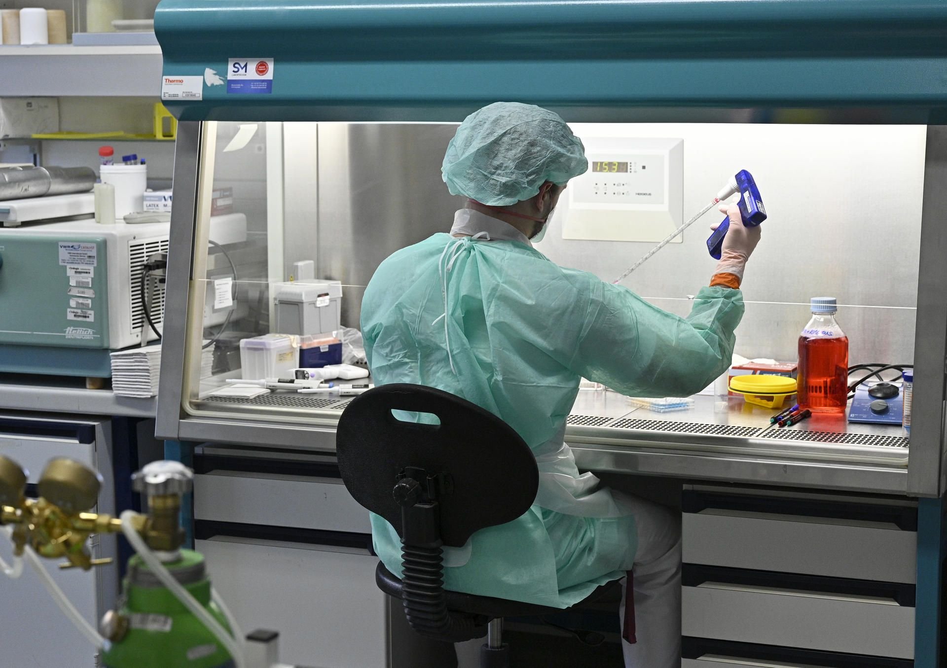 Ein Mitarbeiter eines Labors untersucht eine Probe zur Abklärung des Coronavirus
