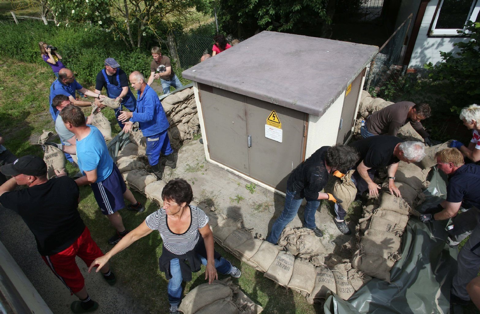 Anwohner schützen mit Sandsäcken eine Trafo-Station bei Schönhausen (Kreis Stendal) vor dem einströmenden Hochwasser.