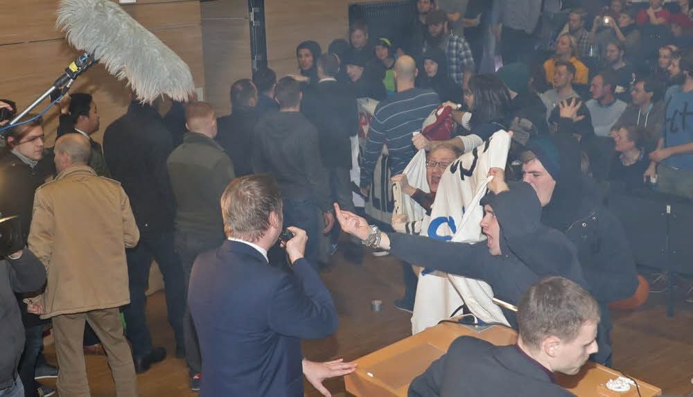 Ein Antifa-Aktivist zeigt AfD-Chef Poggenburg an der Uni Magdeburg den Mittelfinder, der schimpft über „Linksfaschisten“.