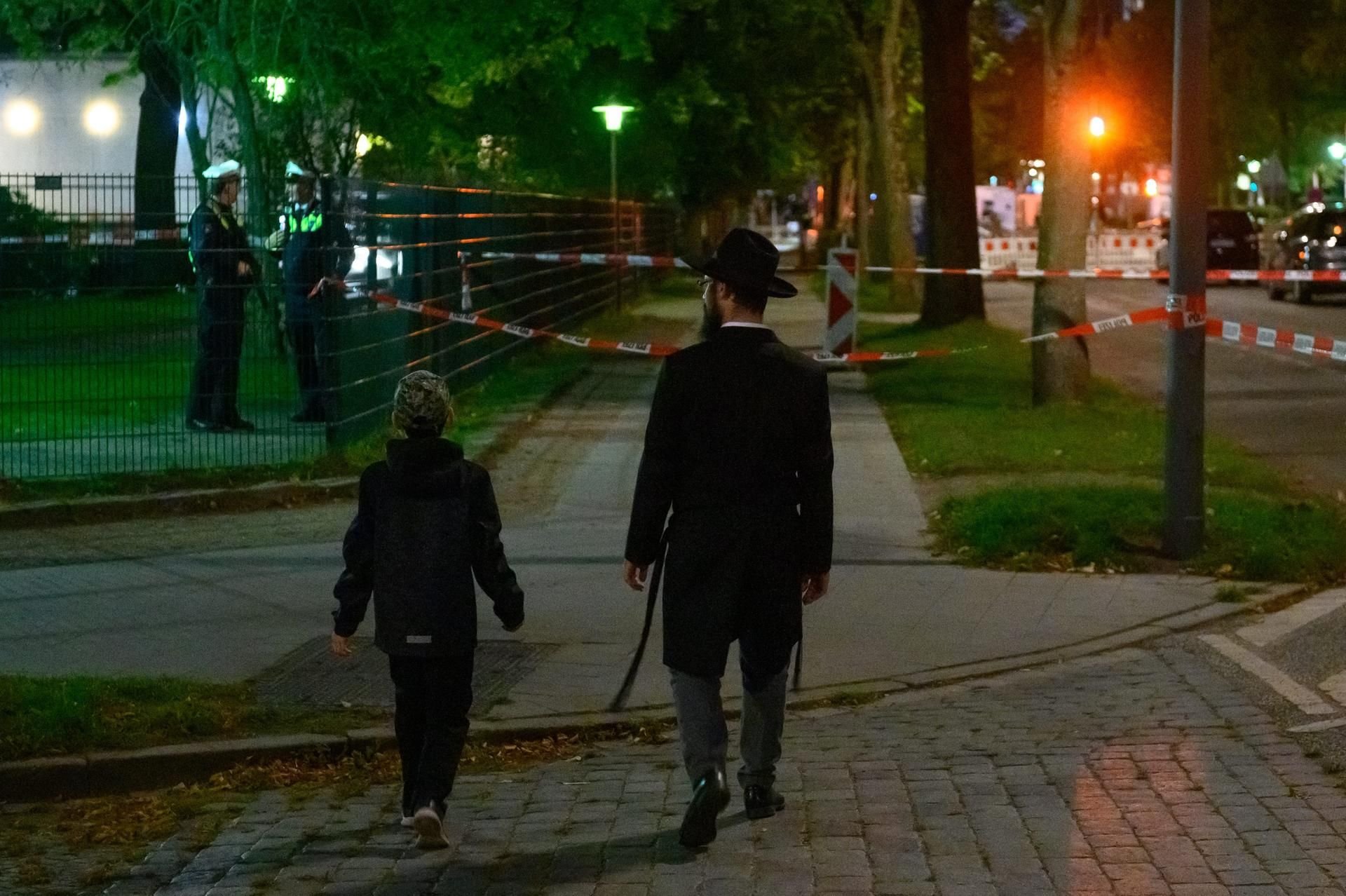 Ein Mann und ein Junge vor dem abgesperrten Bereich vor der Hamburger Synagoge