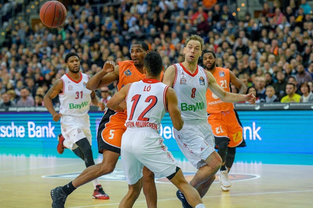 Tremmell Darden (Nummer 5) im Kampf um den Ball gegen zwei Münchener Spieler