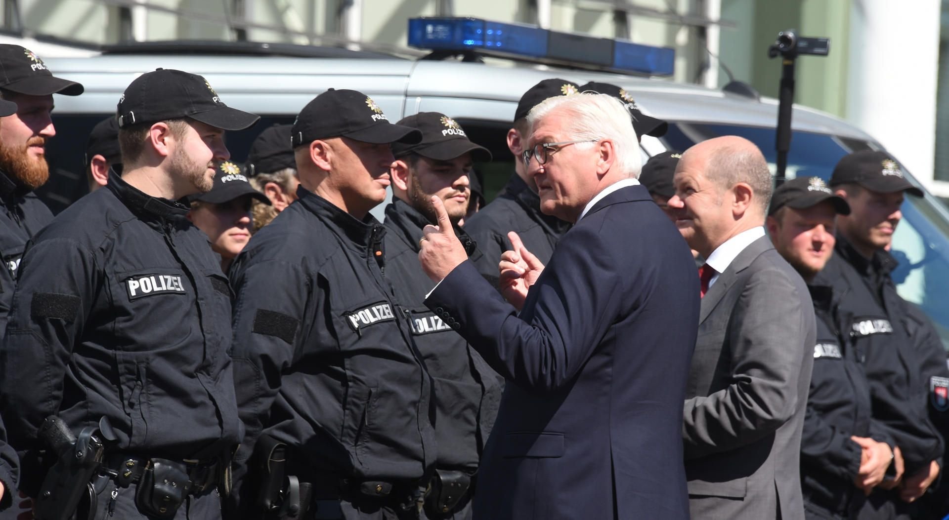 Bundespräsident Frank-Walter Steinmeier (2.v.r) und Hamburgs Erster Bürgermeister Olaf Scholz (SPD, r) sprechen in Hamburg Einsatzkräften der Polizei.