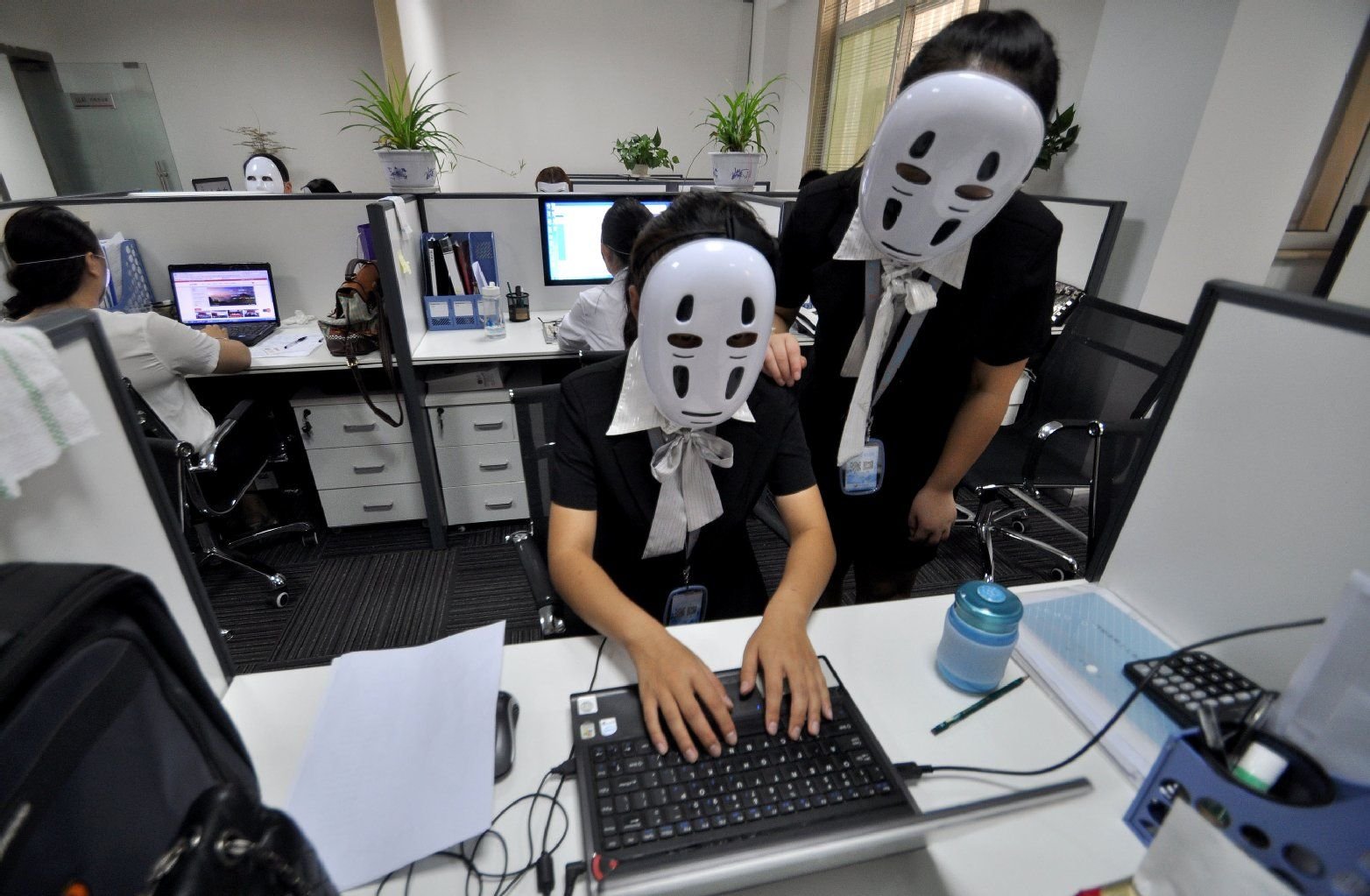 Sie haben genug vom Dauer-Lächeln: Mitarbeiter tragen No-Face-Masken während der Arbeitszeit.