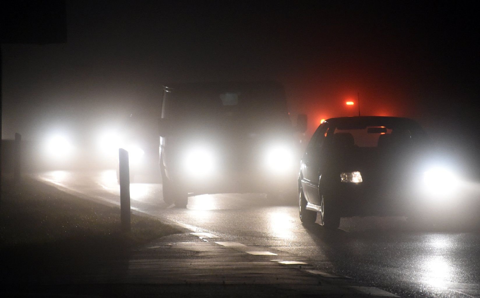Autos fahren im Nebel auf einer Straße.