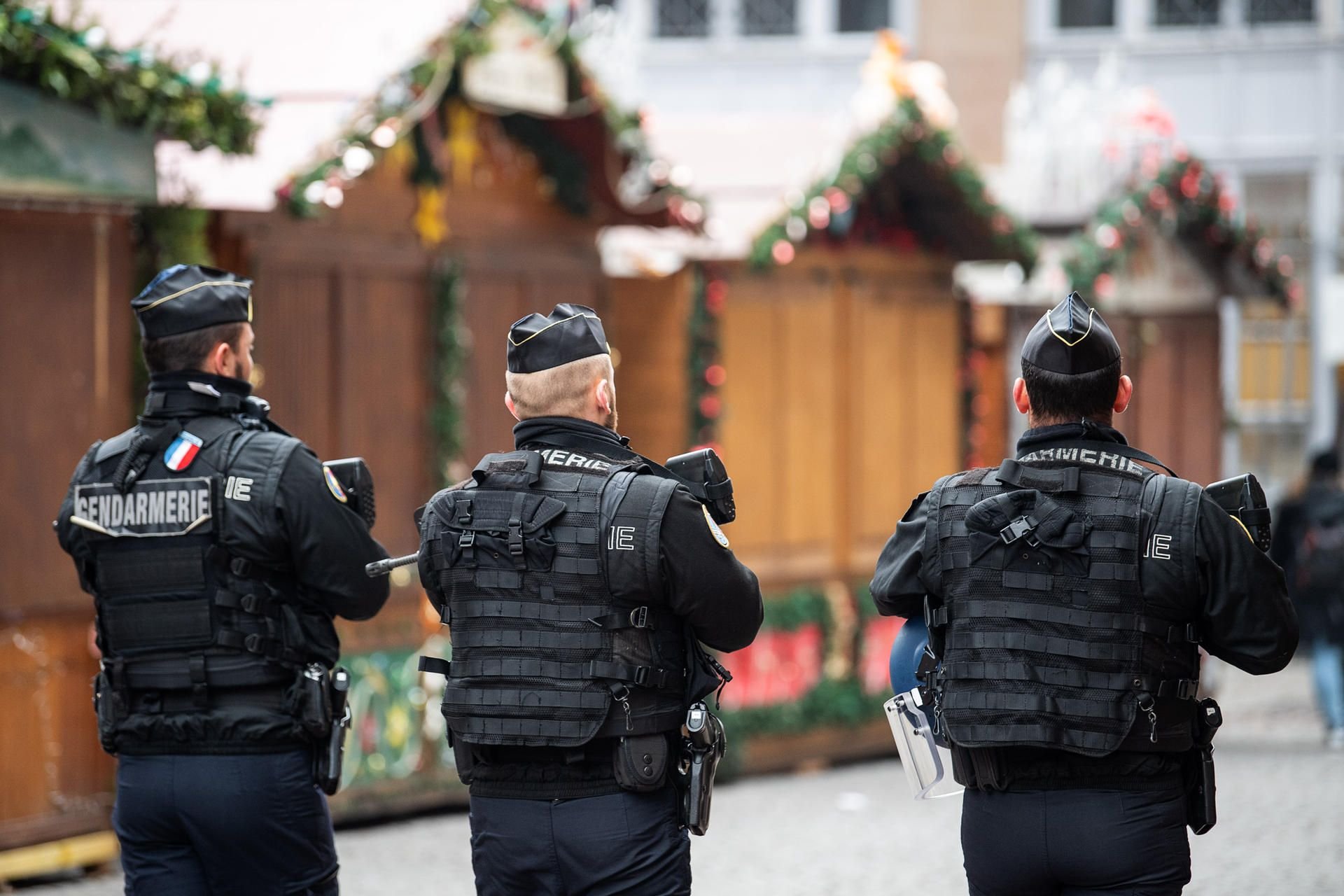 Polizisten gehen nach einem Angriff in Straßburg über den geschlossenen Weihnachtsmarkt.