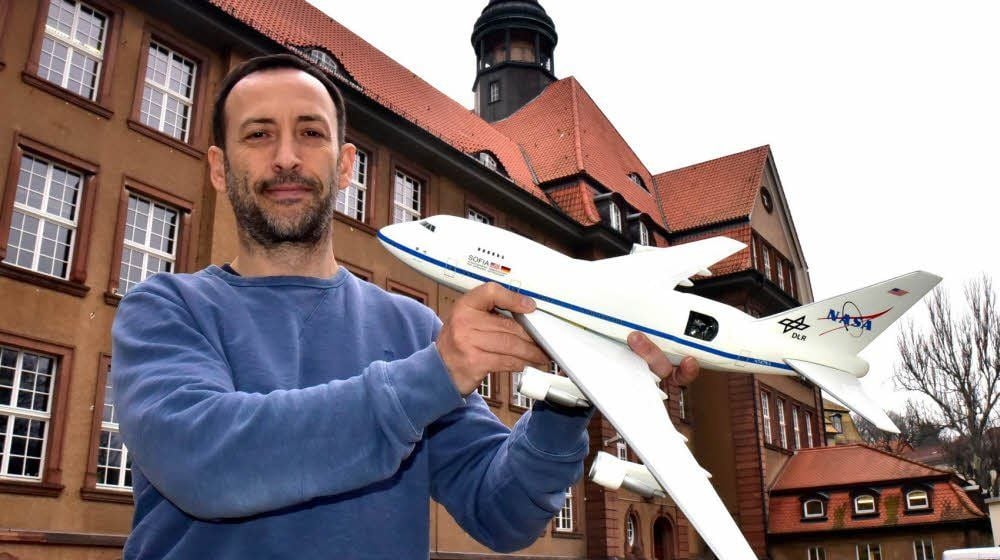 Astronomielehrer Frank Oßwald mit dem Modell eines amerikanischen Forschungsflugzeuges vor dem Weißenfelser Goethegymnasium