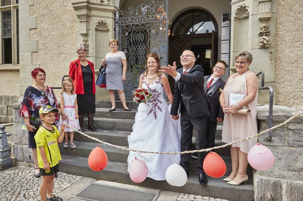 Sandra Schäfer-Erbring und Stephan Erbring kommen nach der Trauung aus dem Rathaus (im Hintergrund Sohn Yannik). Wie es so Brauch ist, wirft der Bräutigam mit Kleingeld, das die Kinder aufsammeln können.