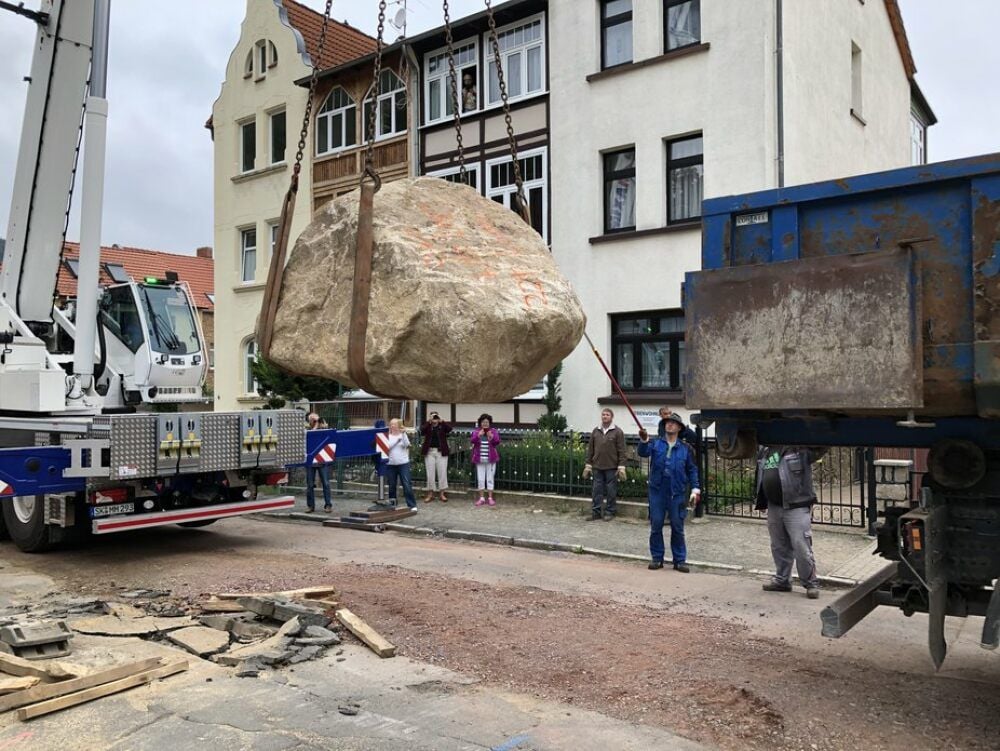 Wenn ein Findling fliegen lernt: Ein Kran hebt den tonnenschweren Stein von der Fahrbahn.