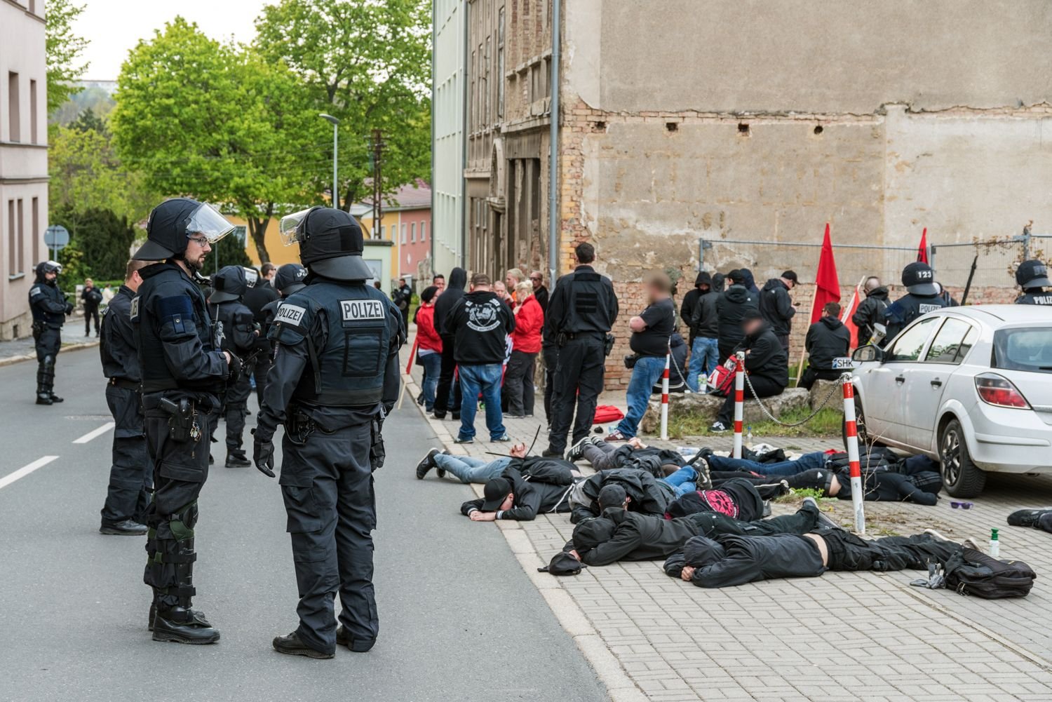 Polizisten stehen vor am Boden liegenden Teilnehmern einer spontanen Demonstration. Dei der Demonstration ist es zu zusammenstößen mit der Polizei gekommen. Die Polizisten vermuten, dass es sich um Anhänger der rechten Szene handelt.