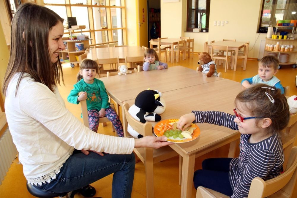 Abstand ist wichtig: Damit die Kinder in der Kita „Benjamin Blümchen“ in Bernburg nicht zu eng sitzen, sitzt immer auch ein Kuscheltier dazwischen. Erzieherin Sophia Endler verteilt nach dem Mittagessen frisches Obst an die Kleinen.