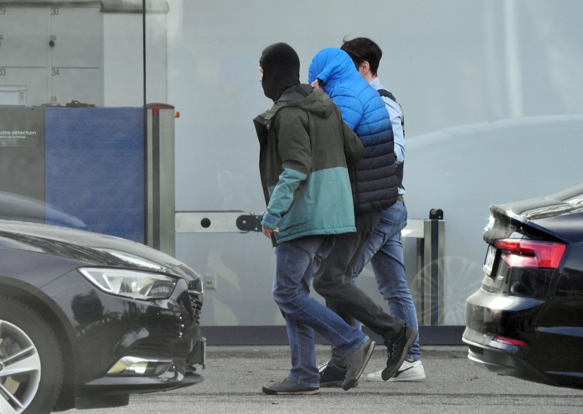 Polizisten führen eine verdeckte Person in den Bundesgerichtshof in Karlsruhe.