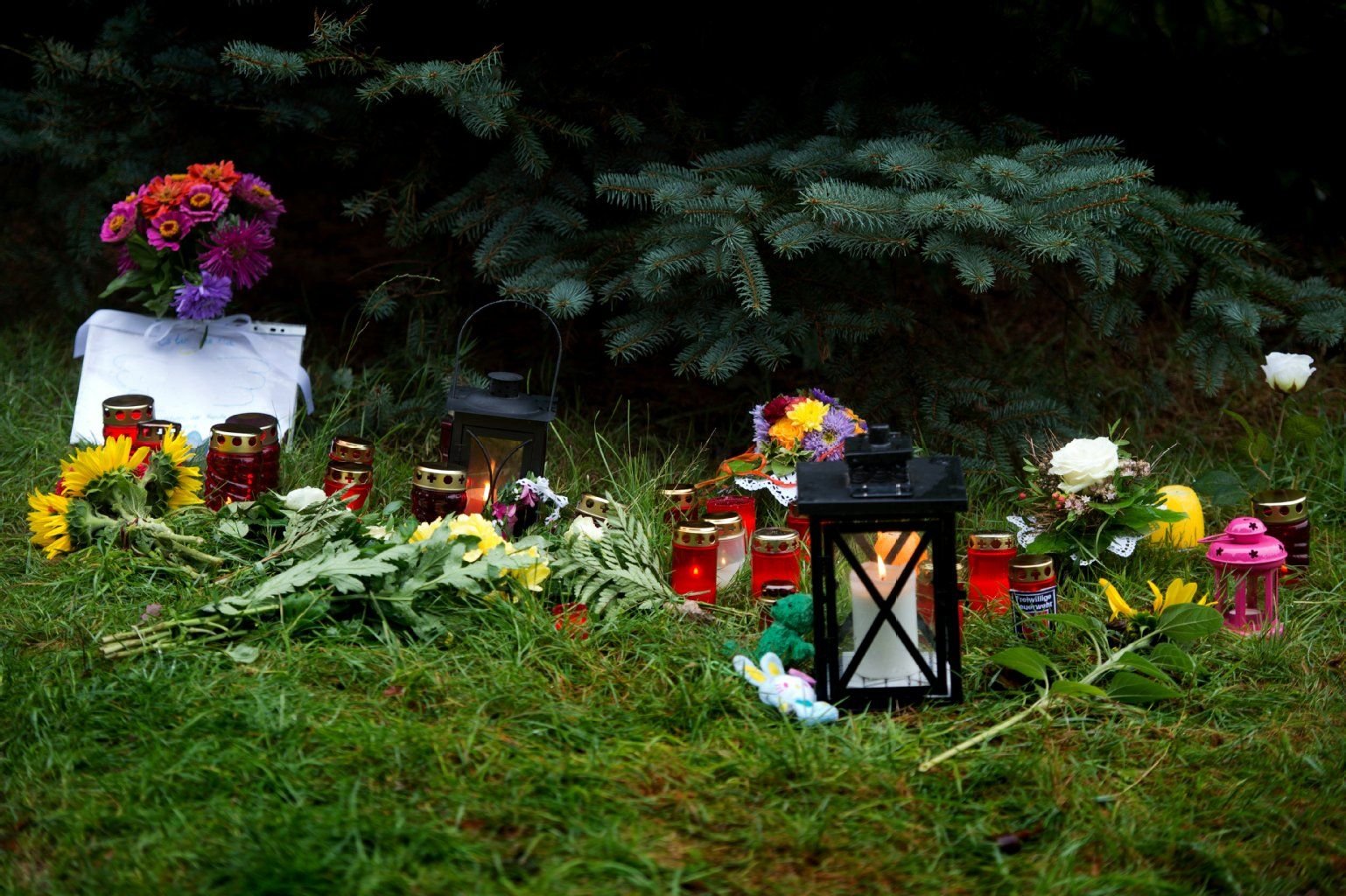 Blumen und Kerzen liegen am 19.08.2015 in Lampersdorf (Sachsen) an der Einfahrt des Bauernhofes, in dem die Polizei die entführte und ermordete 17-jährige Anneli gefunden hat.