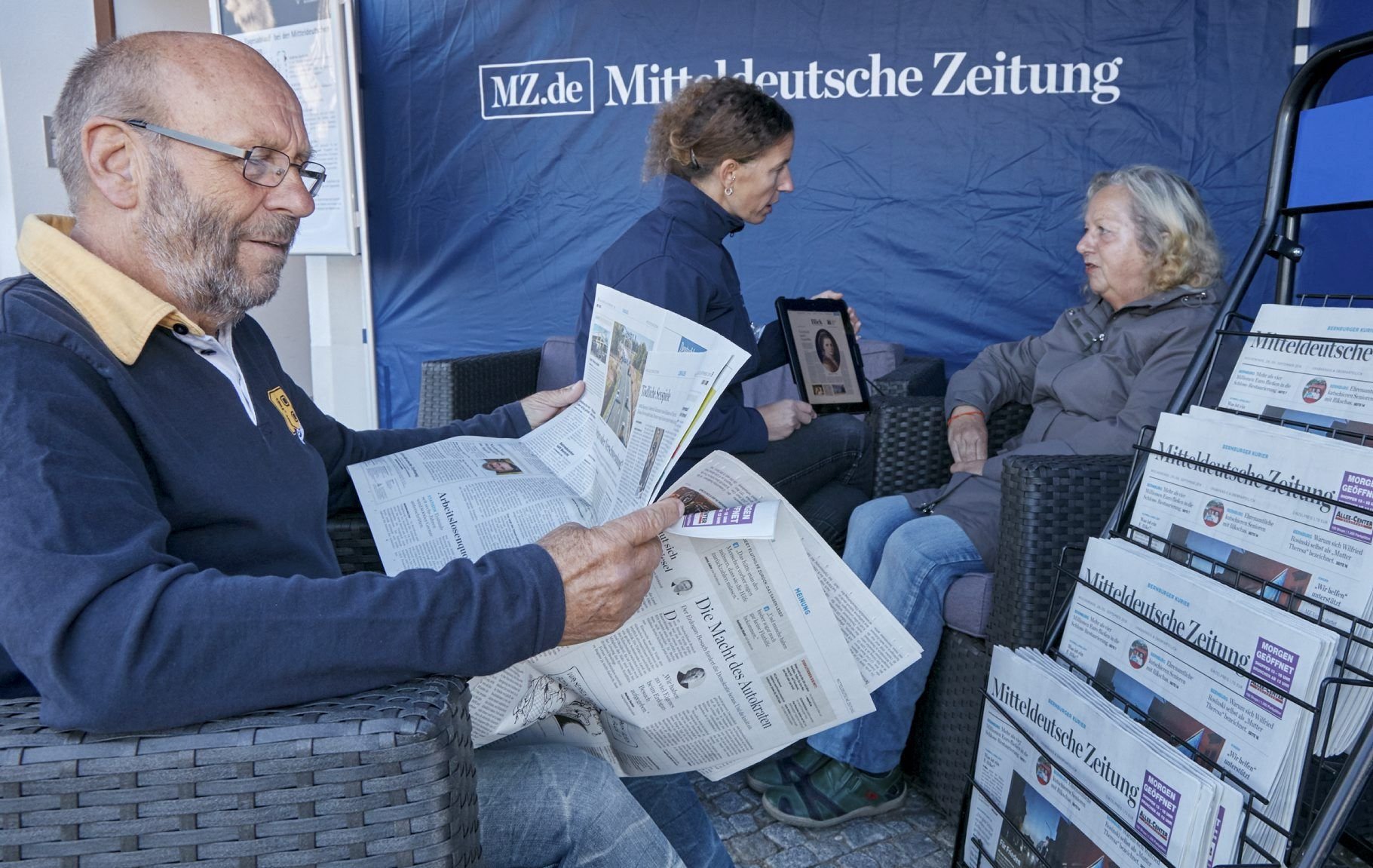 Lothar Beinert liest und Ilona Pompe (r.) lässt sich von Sarah Scheibler zeigen, wie Zeitung digital funktioniert. Sie ist überzeugte Leserin der Papierzeitung.