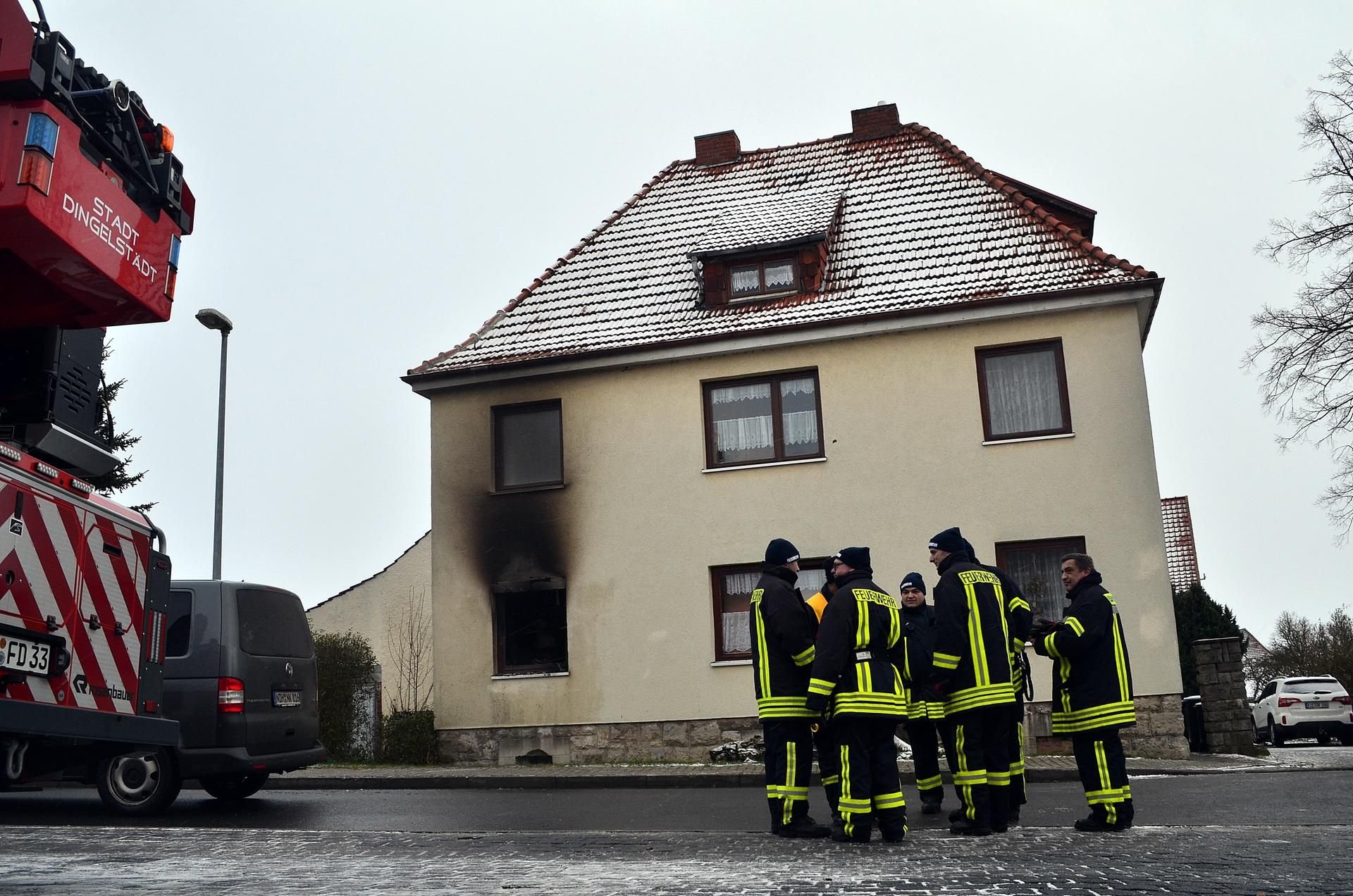 Feuerwehrleute stehen in Dingelstädt vor dem Haus, in dem bei einem Wohnungsbrand eine 83-Jährige und ihr 74 Jahre alter Mann ums Leben kamen.