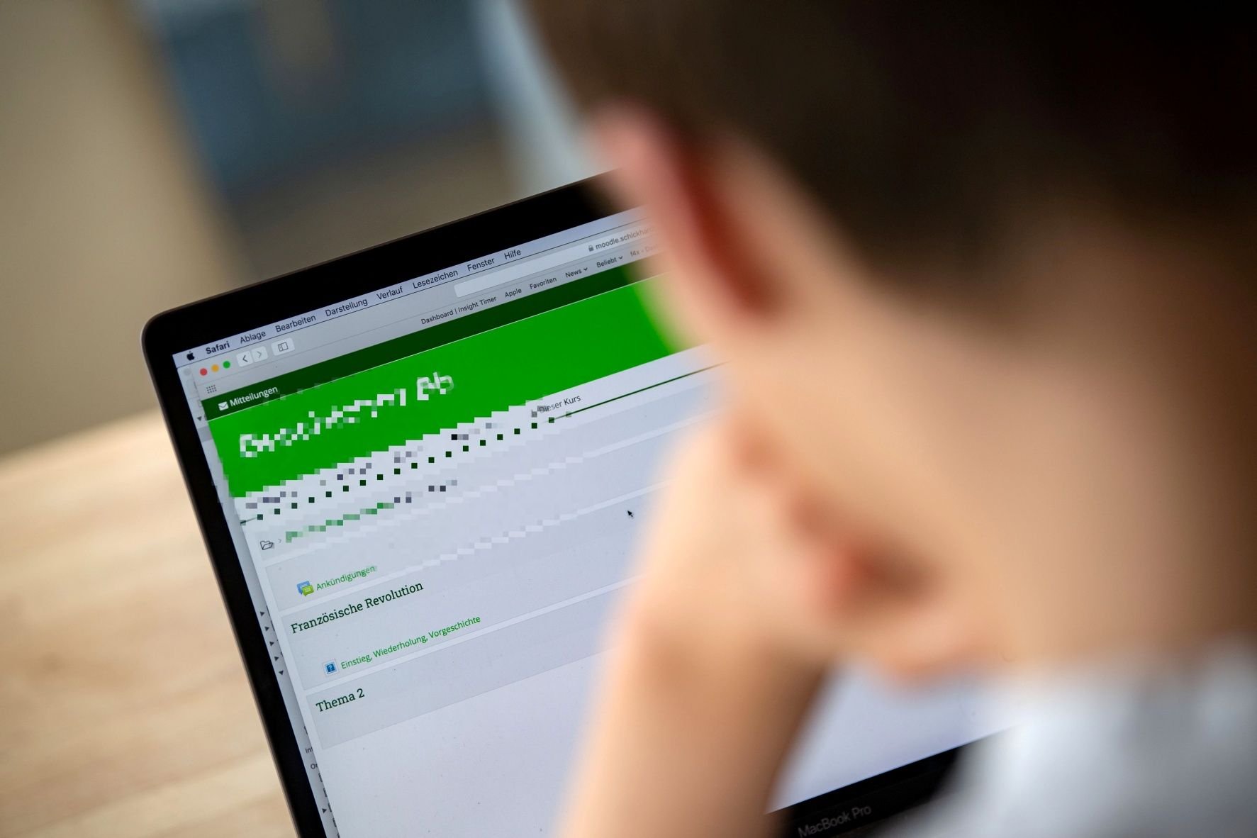 Ein Schüler der 8. Klasse eines Gymnasiums bedient an einem Notebook eine Lernplattform