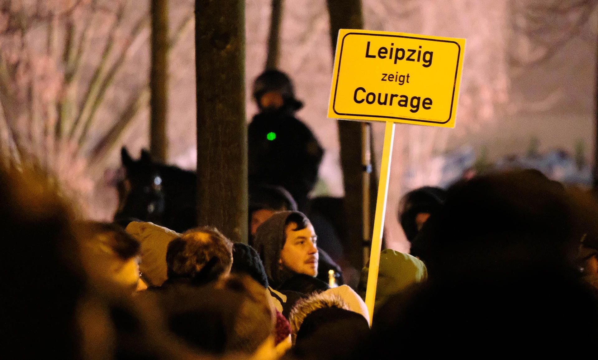 Teilnehmer einer Gegen-Demonstration stehen in Leipzig in der Nähe eines Aufmarsches des fremdenfeindlichen Bündnisses Legida.