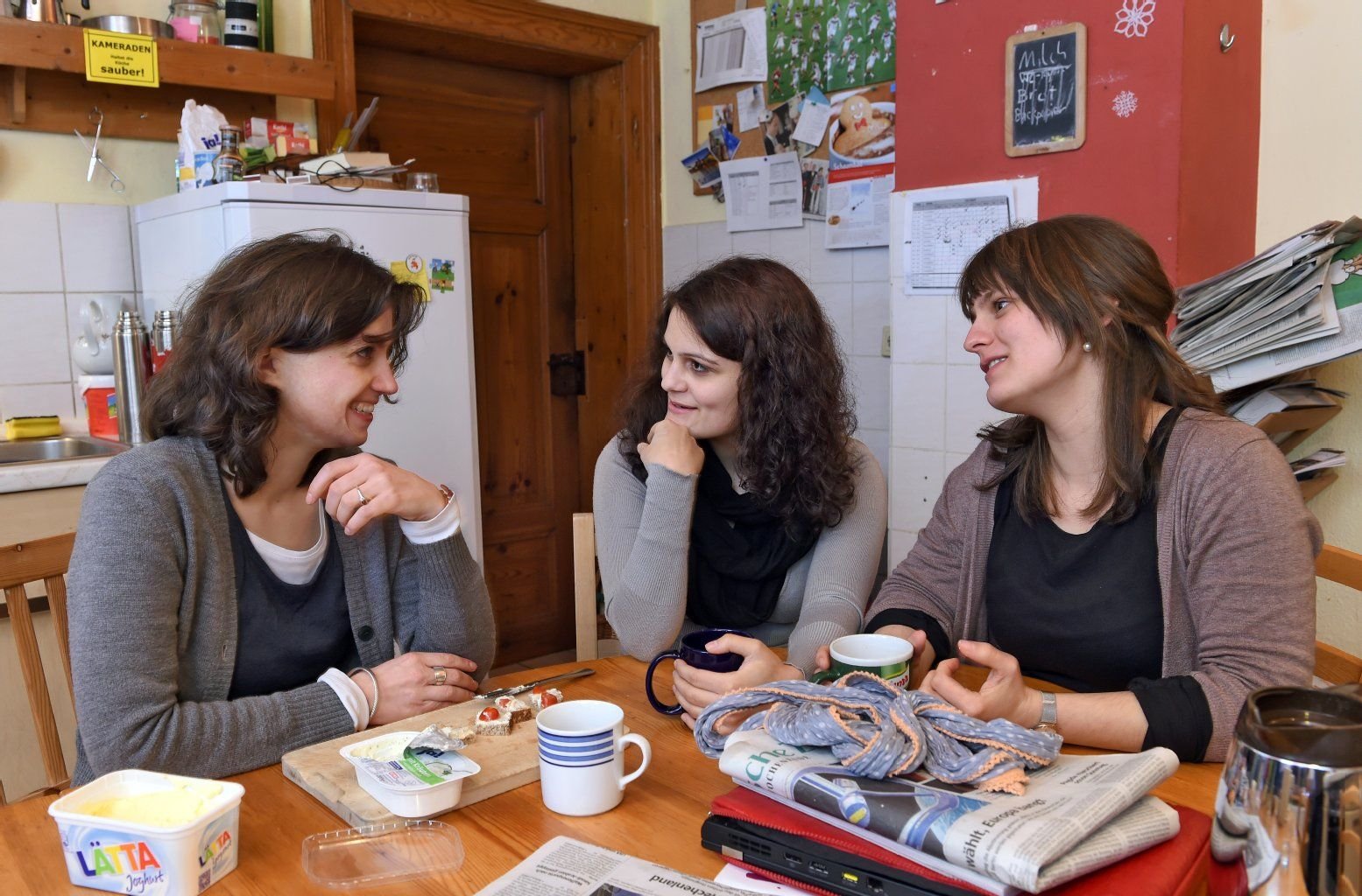 In der Küche des Christlichen Studentenhauses in Halle unterhalten sich Anna Schönfelder (l), Sarah Wettrau und Pauline Starke (r).