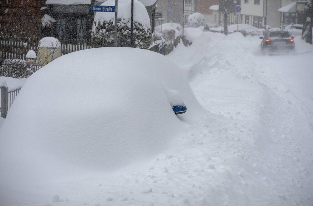 Nur der Spiegel guckt noch heraus: ein vollkommen unter den Schneemassen verschwundenes Auto.