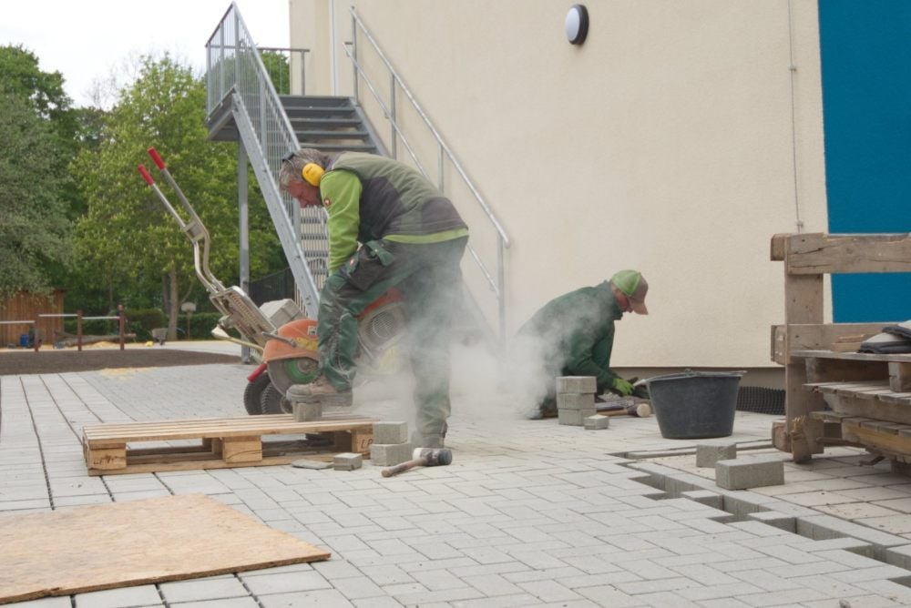 Andy Appenroth (r.) und Helmut Hulsch (l.) von der Firma Landschaftsbau Horenburg bei Pflasterarbeiten im Außenbereich.