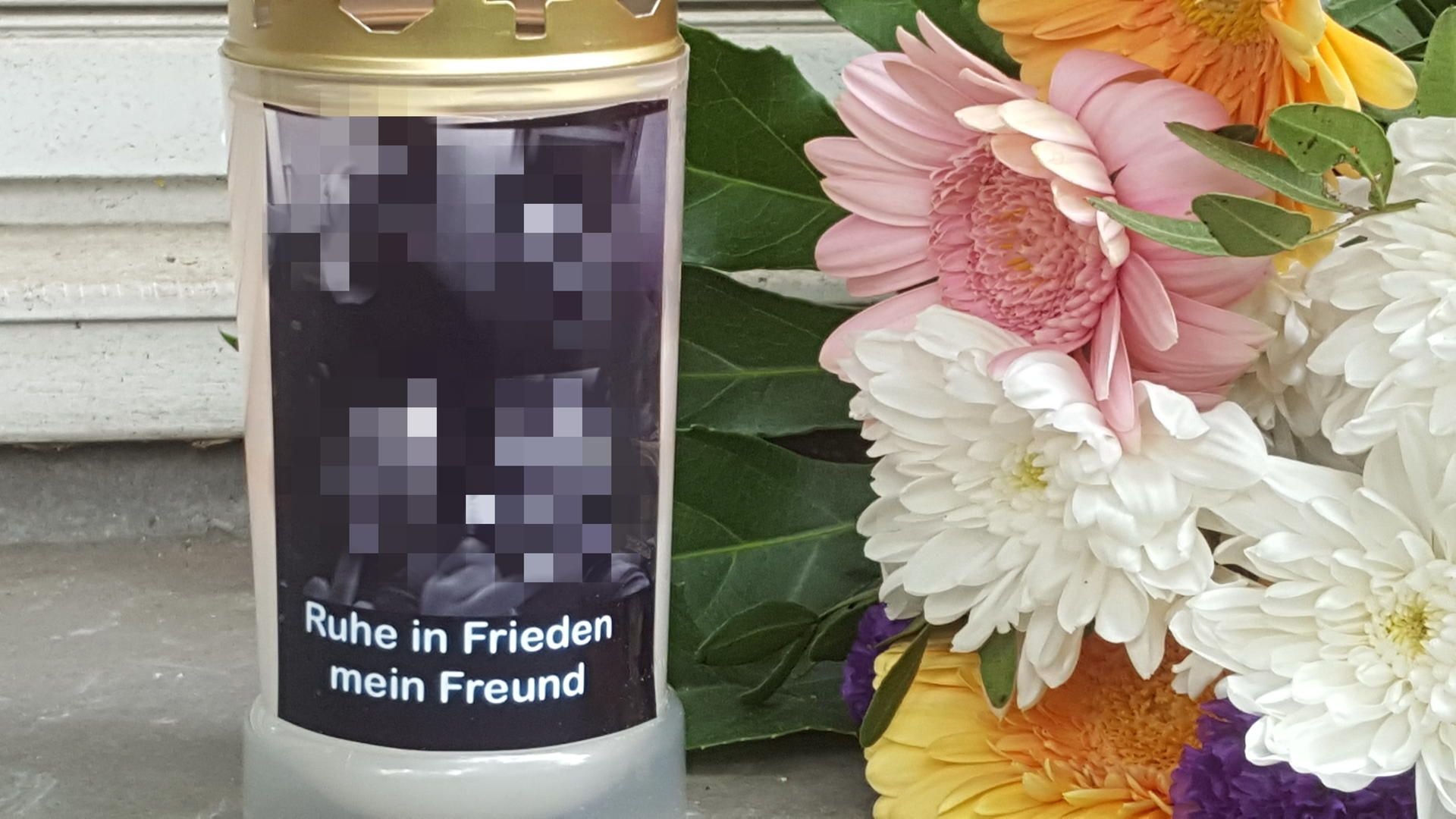 Kerze und Blumen für toten Polizeischüler