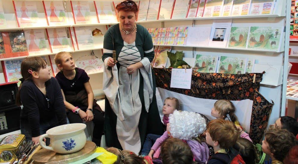 Lauschen und schauen: Ilonka Struve erzählt den Kindern am Stand ihres Verlages ein neues Märchen.