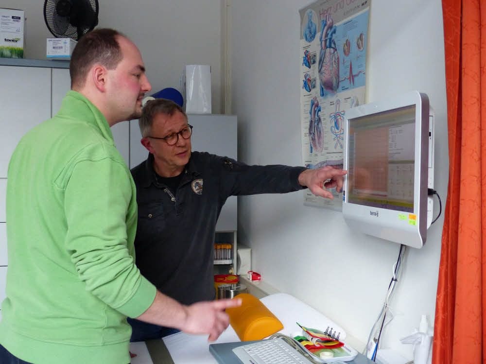 Medizinstudent Stephan Müller (vorn) aus der „Klasse Allgemeinmedizin“ und sein Mentor, der Arzt André Wagner, besprechen ein EKG.