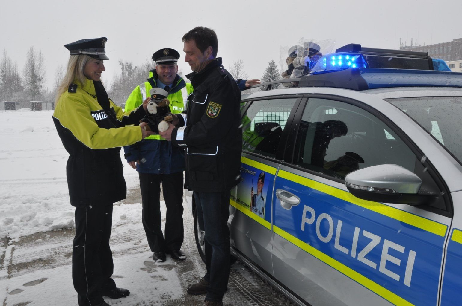Landespolizeipfarrer Michael Bertling (r.) übergibt einige der neuen Polizeiteddys an Susan Resetaritz (l.) vom Dezernat für Prävention und ihren Kollegen Heiko Mosch (M.) vom vom Dezernat Verkehr.