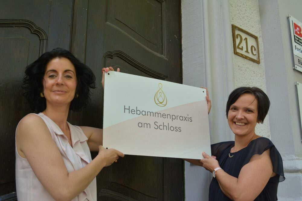 Jana Schmidtke (links) und Nadine Bauer mit dem Schild, das an der Fassade des Hauses Zeitzer Straße 21c angebracht wird.