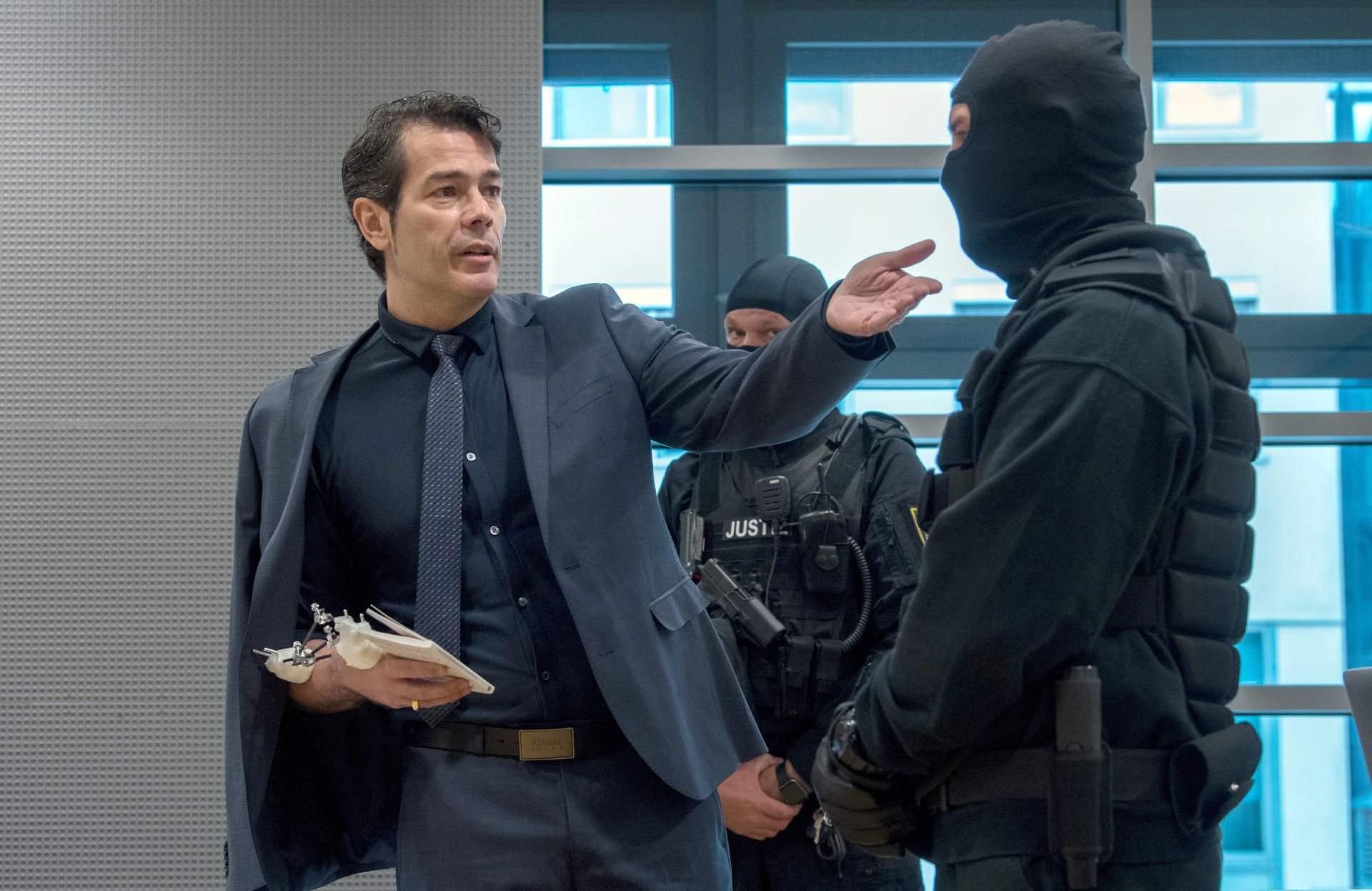 Der ehemalige "Mister Germany" Adrian Ursache (l.) spricht im Landgericht in Halle (Saale) mit dem Grundgesetz in der Hand vor Prozessbeginn im Gerichtssaal einen Justizbeamten an.