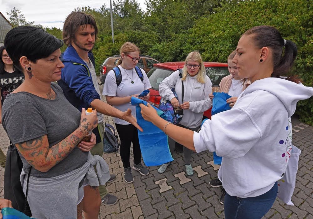 Die jungen Leute vom Jugendforum - erkennbar an den weißen Jacken und T-Shirts - verteilen die Müllsäcke, die es zu befüllen gilt.