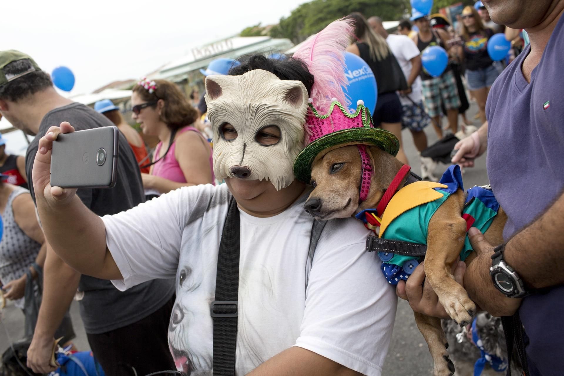 Karneval in Rio de Janeiro: Eine Frau macht auf einer Karnevalsparade für Hunde ein Selfie mit Hund Kaike.