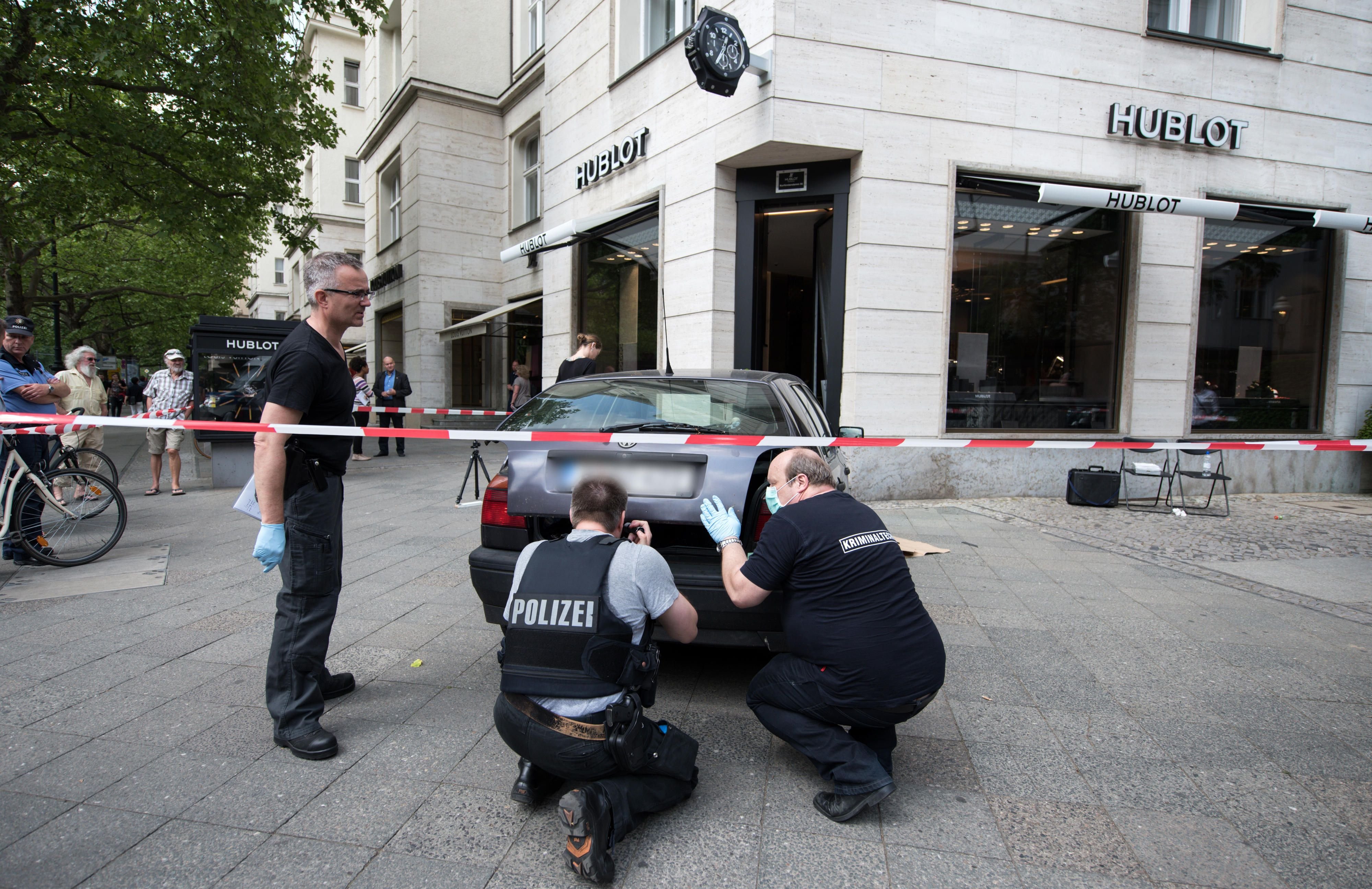 Kriminaltechniker der Berliner Polizei sichern vor einem Juweliergeschäft am Kurfürstendamm in Berlin an einem Auto Spuren.
