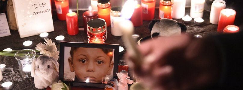 Menschen legen Kerzen und Blumen für den toten Mohamed am Lageso nieder.