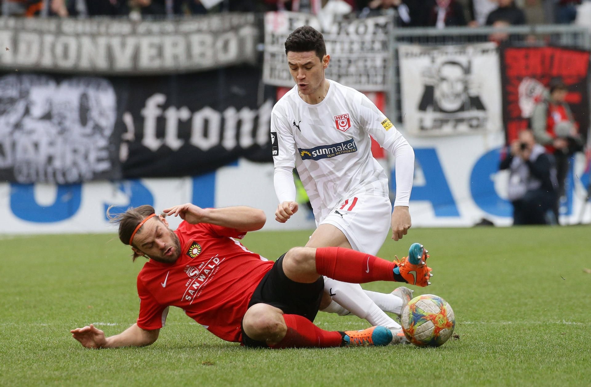Aspachs Timo Röttger grätscht gegen Halles Niklas Landgraf.