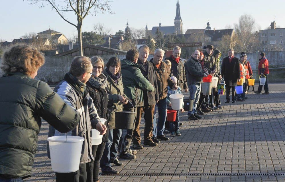 Zahlreiche Bürger, darunter auch einige OB-Kandidaten, packten bei der Eimerkette am Ratswall in Köthen mit zu.