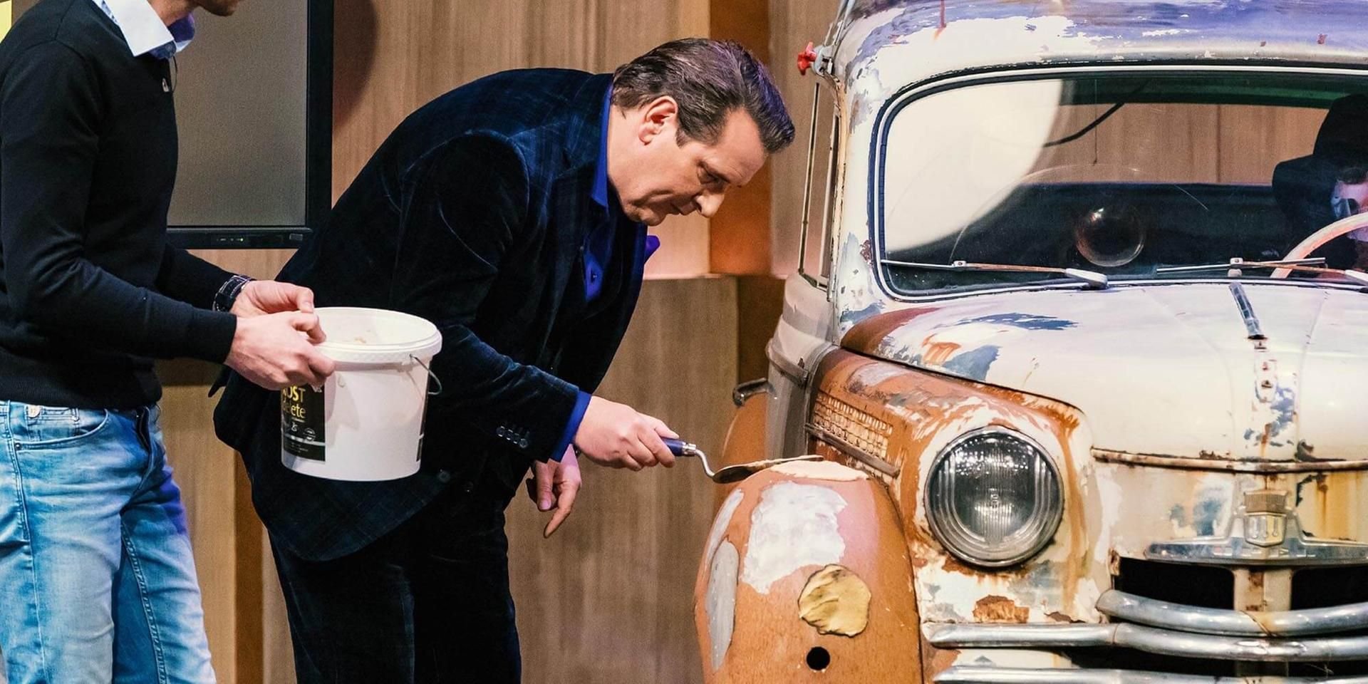 Löwe Ralf Dümmel testet ROSTdelete an einer rostigen Karosse.
