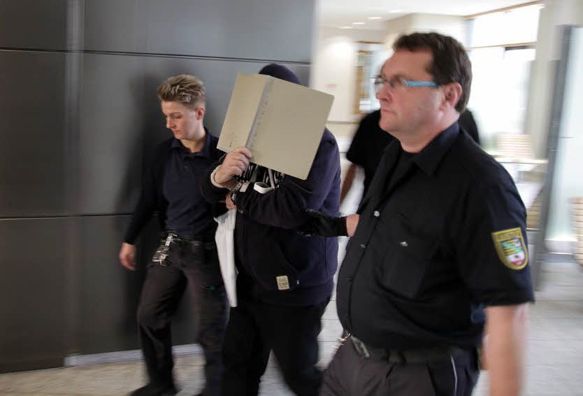 Der Angeklagte Heinz-Dieter D. wird gefesselt von Justizmitarbeitern ins Gericht geführt.